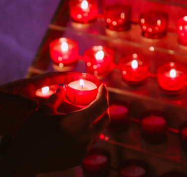 Hand holding a votive candle