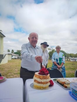Man cutting celebration cake