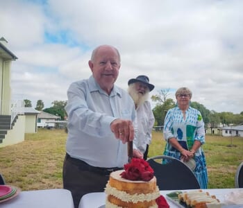 Man cutting celebration cake