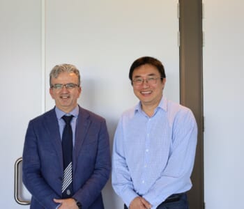 Two men posed together smiling