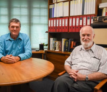 Two men sitting at a table in an office
