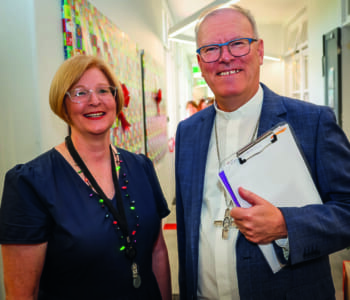 Two people posed smiling, one is a woman the other is a man