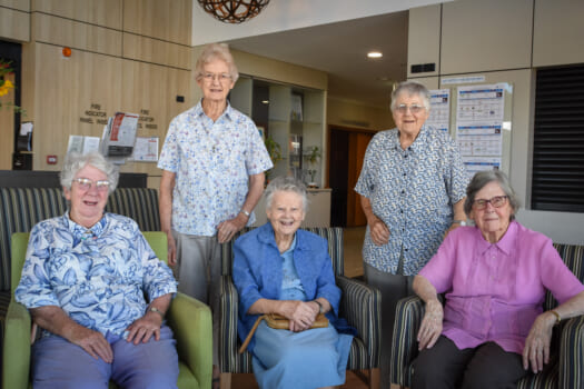 A group of five elderly ladies posed smiling